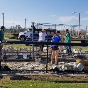 School and community members working to clean up the softball field.