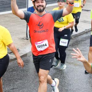 A DP World employee waves while running during the 40th edition of the 10KM Tribuna FM Race in Santos, Brazil.