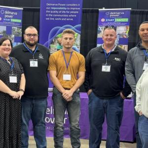 A group of people stood in front of event banners 
