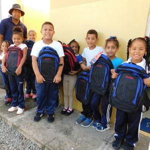 Children shown with their new back to school backpacks.