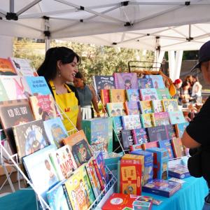 An attendee browses the book collection at Lil' Libros pop-up shop.