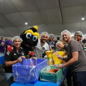 LA Galaxy's mascot Cozmo helps pack meals with volunteers from LA Galaxy.