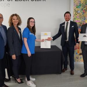 A group of women and men flip an oversized light switch