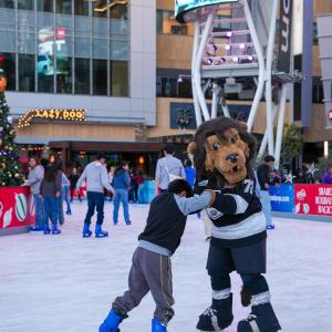 LA Kings mascot Bailey taught a young child how to ice skate during AEG's Community Holiday Party in Los Angeles, CA.