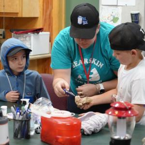 A camp staff member at Bearskin Meadows Camp, a camp for children living with Type 1 diabetes, helps young campers measure their blood glucose levels. The camp has received donated diabetes management products from embecta via Direct Relief. (Kim Ofilas/Direct Relief)