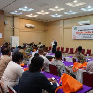 Person speaking at an event with people sitting at tables