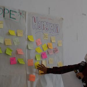 Person puts sticky notes on an idea board