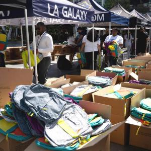Employees from AEG, LA Galaxy and LA Kings help pack backpacks for under-resourced students at their school supplies drive.
