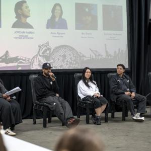 Five panelists participate in an industry discussion at the Portola College Connection Program, with one panelist speaking into a microphone as attendees watch.