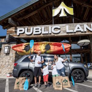 Jax Ramirez and his family pictured in front of Public Lands. A kayak is loaded on top of the family car.