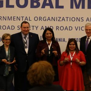 A group of people posing for a folder with 3 holding awards