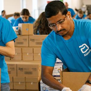 people in aqua abbott t-shirts packing boxes