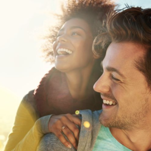 Two people smile while getting a piggy back ride