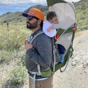 Daniel Leyba and his child asleep in a snuggie.