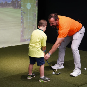 A young golfer receiving lessons from a pro.