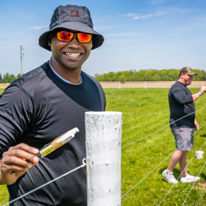 Smiling volunteers painting a fence