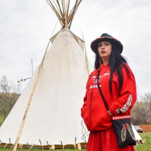 Deborah in traditional costume, a teepee behind her.