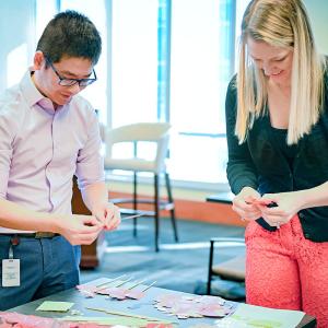 Two people stood at a table making decorations 