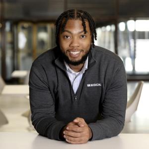 Demarcus Reaves leaning on a desk smiling