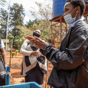 Mrs Ratshisevhe NC, a senior educator who is responsible for sanitation, hygiene and menstrual health at Ligege Secondary School in South Africa, teaches good handwashing practices at the school's new handwashing station.