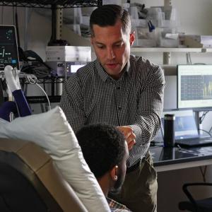 Image of lab manager attending to a patient 