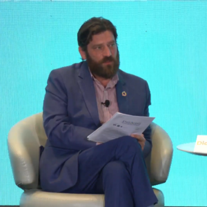 The image features Didier Bergeret moderating a panel