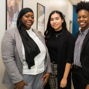 Three people standing together and smiling at the camera