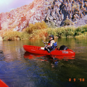Dina in a kayak on a river.