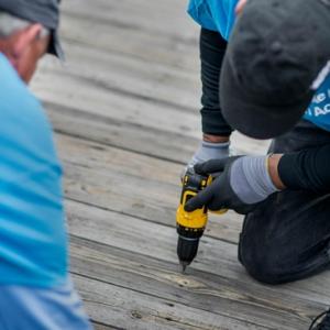 Two people building using a screw gun