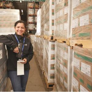 A person leant against pallets in a distribution center 