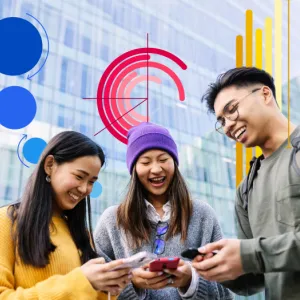 Three Asian people looking at their phones and smiling.