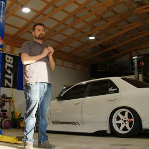 Jacob standing next to white car