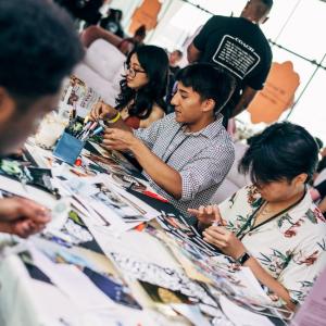 Group sitting at a table cutting paper and making artwork