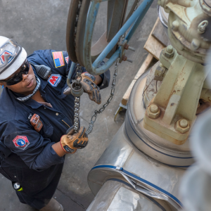 Dynita McCaskill looking up at industrial equipment chain.