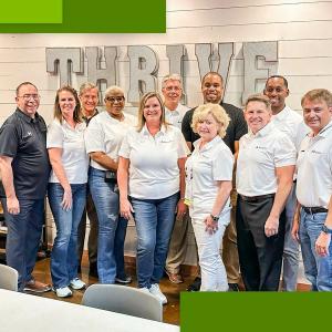 Group of Regions volunteers stood infront of a 'TRHIVE' sign