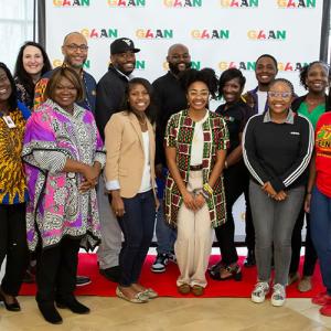 A large group photo taken in front of a GAAN back drop 