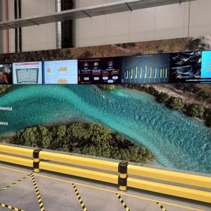 A long board in an industrial setting "Environmental, Social, Governance." Over an image of a river. Smaller display boards on top.