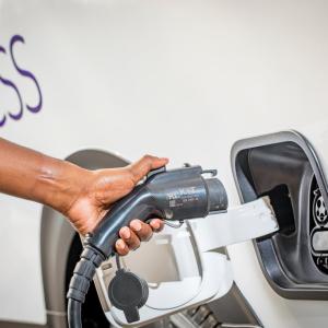 person plugging in an electric vehicle