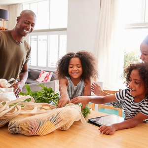Family shown with reusable shopping bags.
