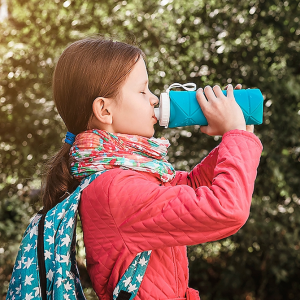 Young girl sipping a water bottle.