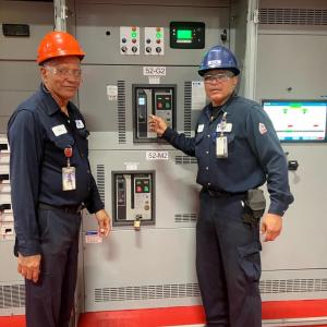 Eaton employees standing with circuit breakers 