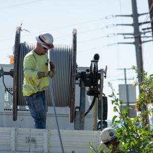 Employees installing wire covered with a protective coating