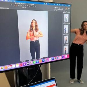 Emily Vaughn in front of a giant monitor. 