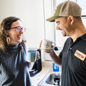 The Santoros laughing, holding coffee mugs.