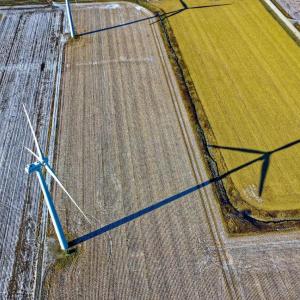 Aerial view of farms with wind turbines and a country road