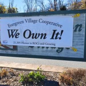 Evergreen Village Cooperative banner: "We Own It".