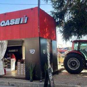 A Case IH sign above a small store with products on shelves. Tractor to the right.