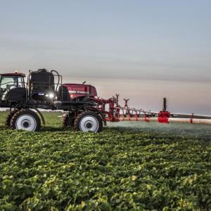 A large farming vehicle spraying a crop field