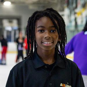A student stops for a photo as he ice skates for the first time.