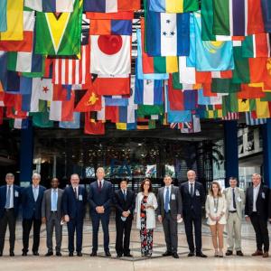 Group of people standing under a large display of many flags